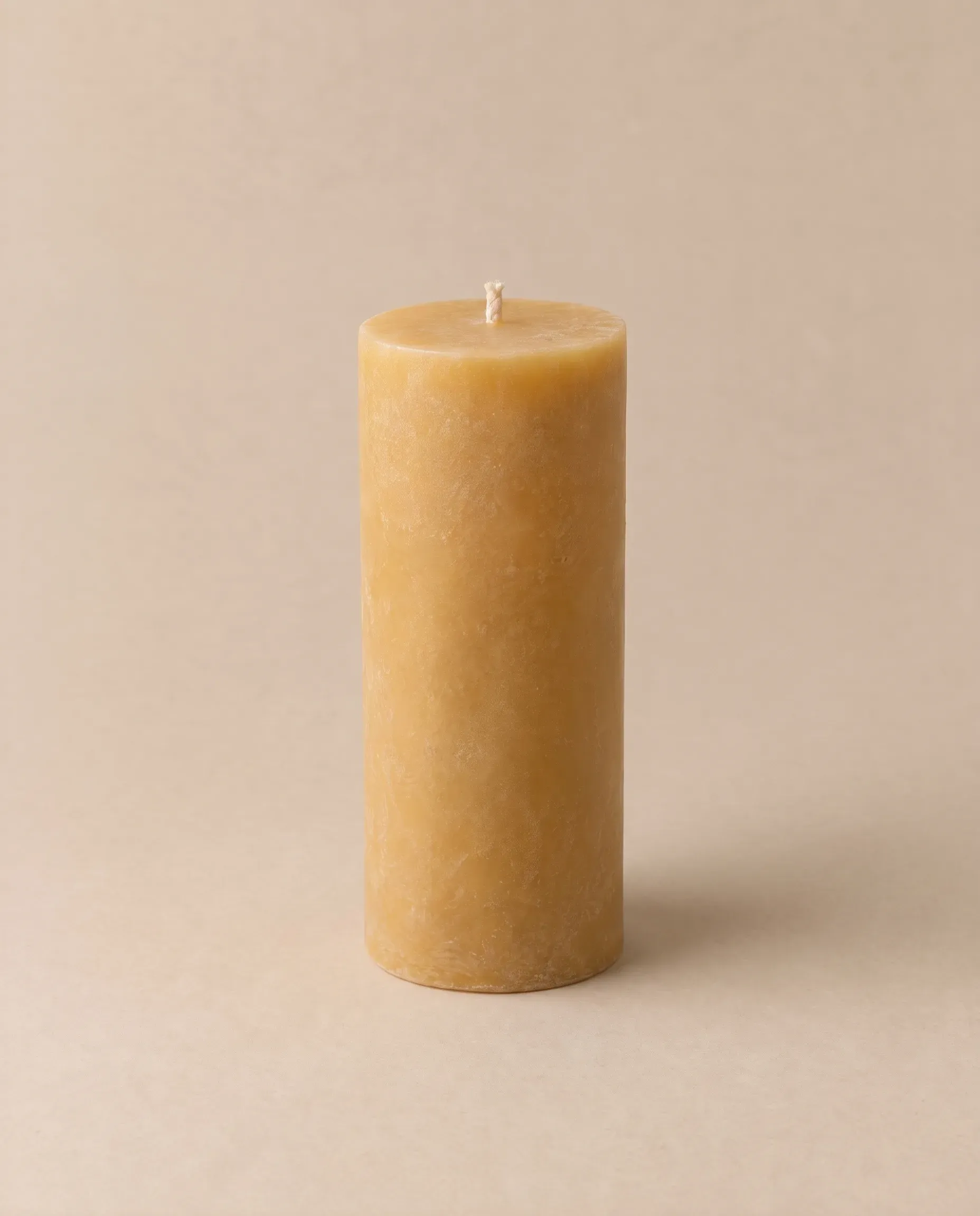 A golden beeswax pillar candle, 15 cm