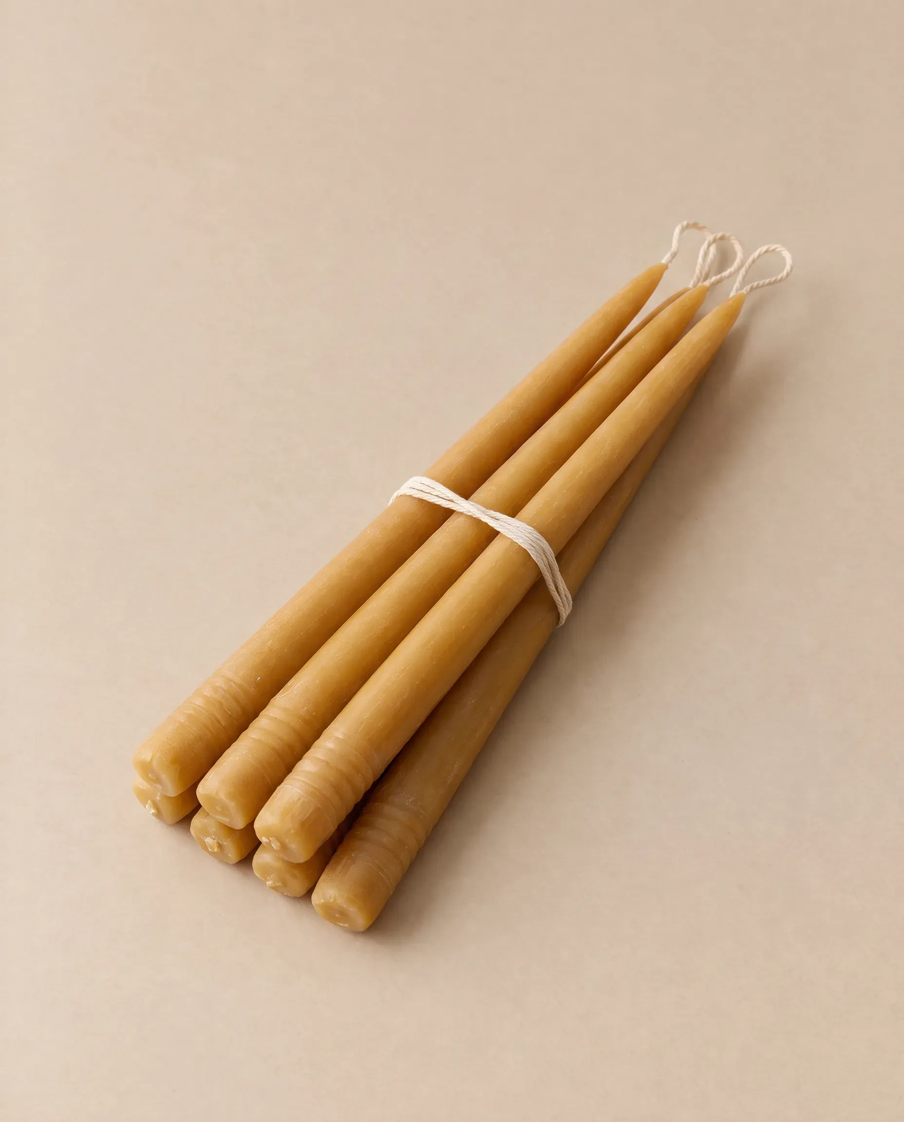 Six hand-dipped beeswax taper candles tied with cotton string