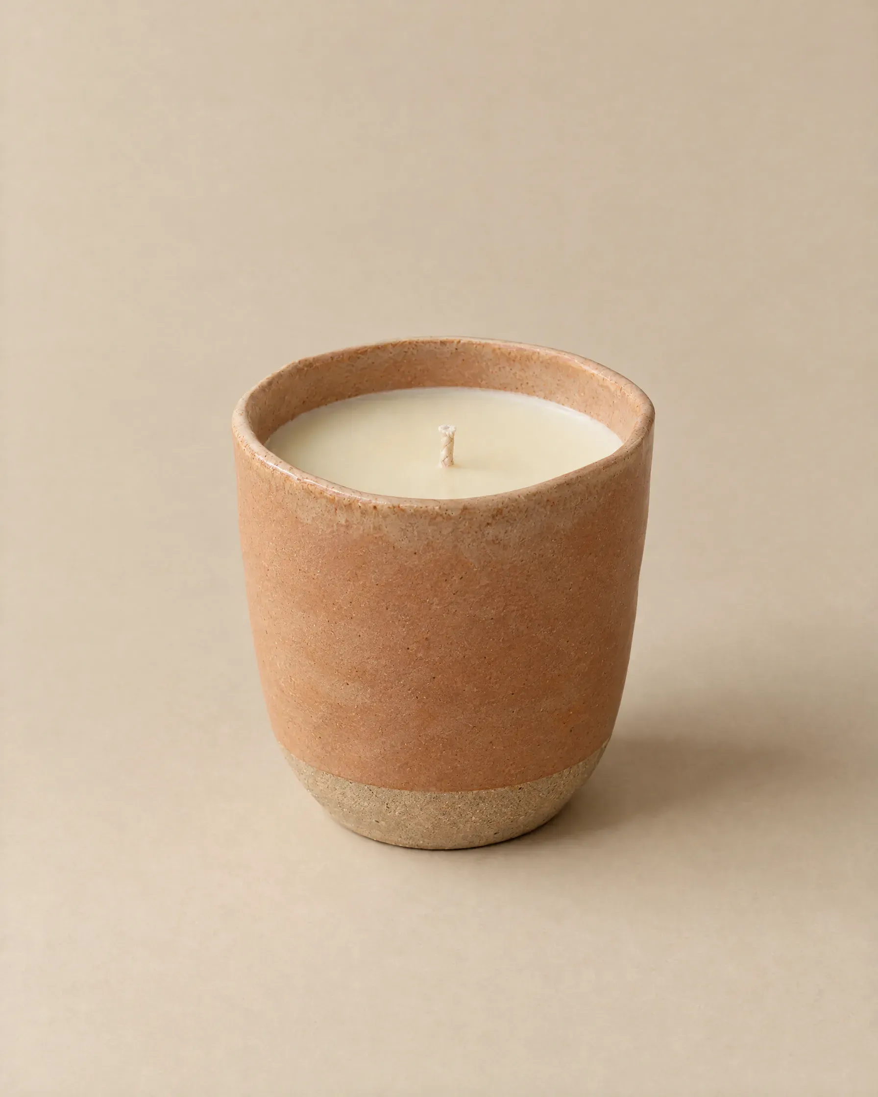 Beeswax candle in a terracotta-sand stoneware cup