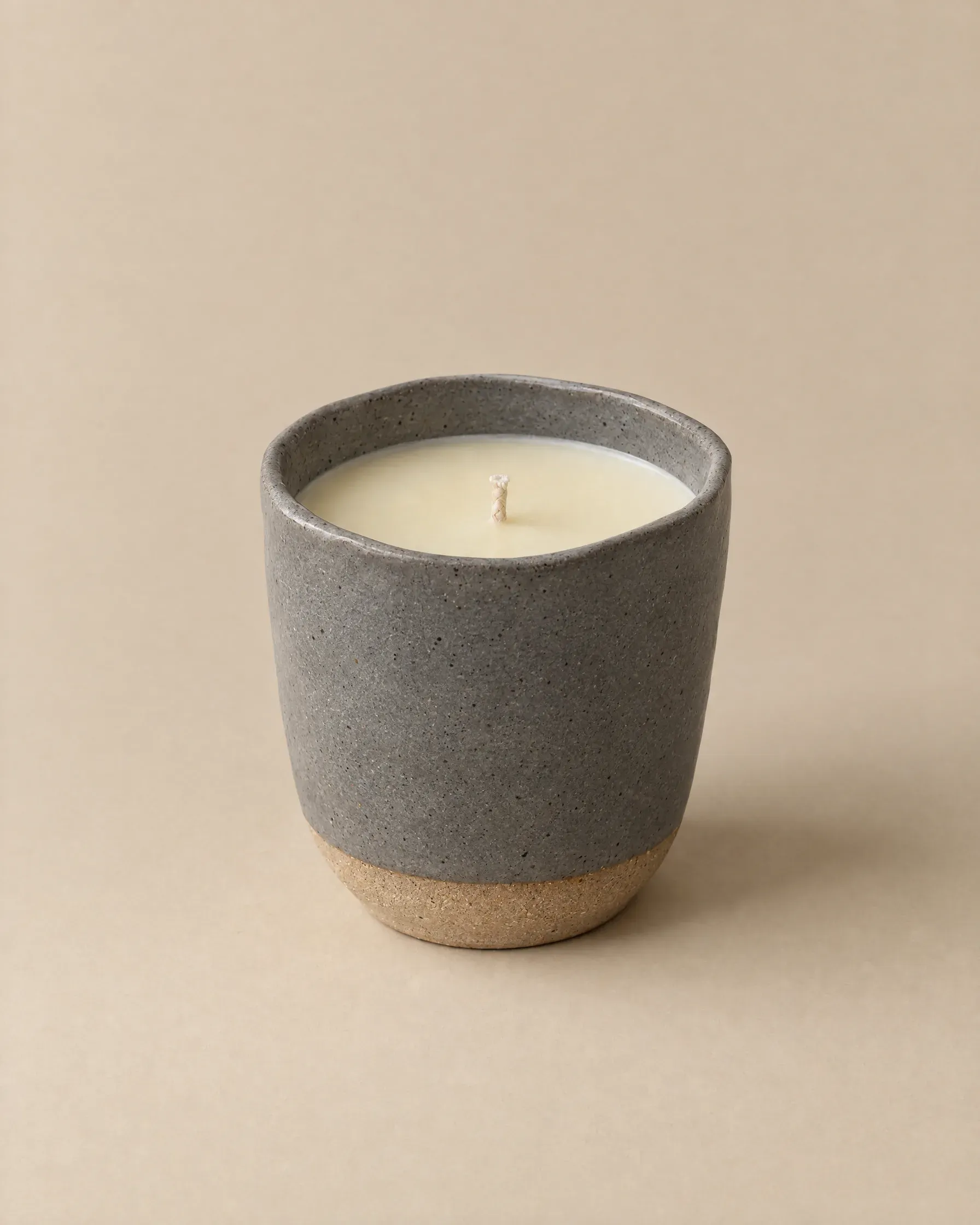 Beeswax candle in a speckled ash-grey stoneware cup